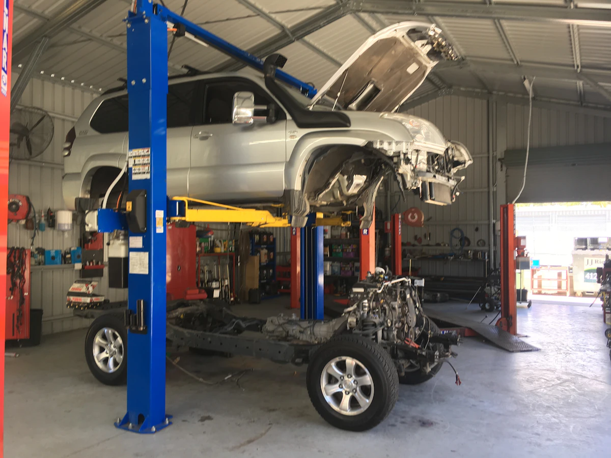 {{{businessName}}} mechanics replacing rusted underbody on Toyota Prado (side view).